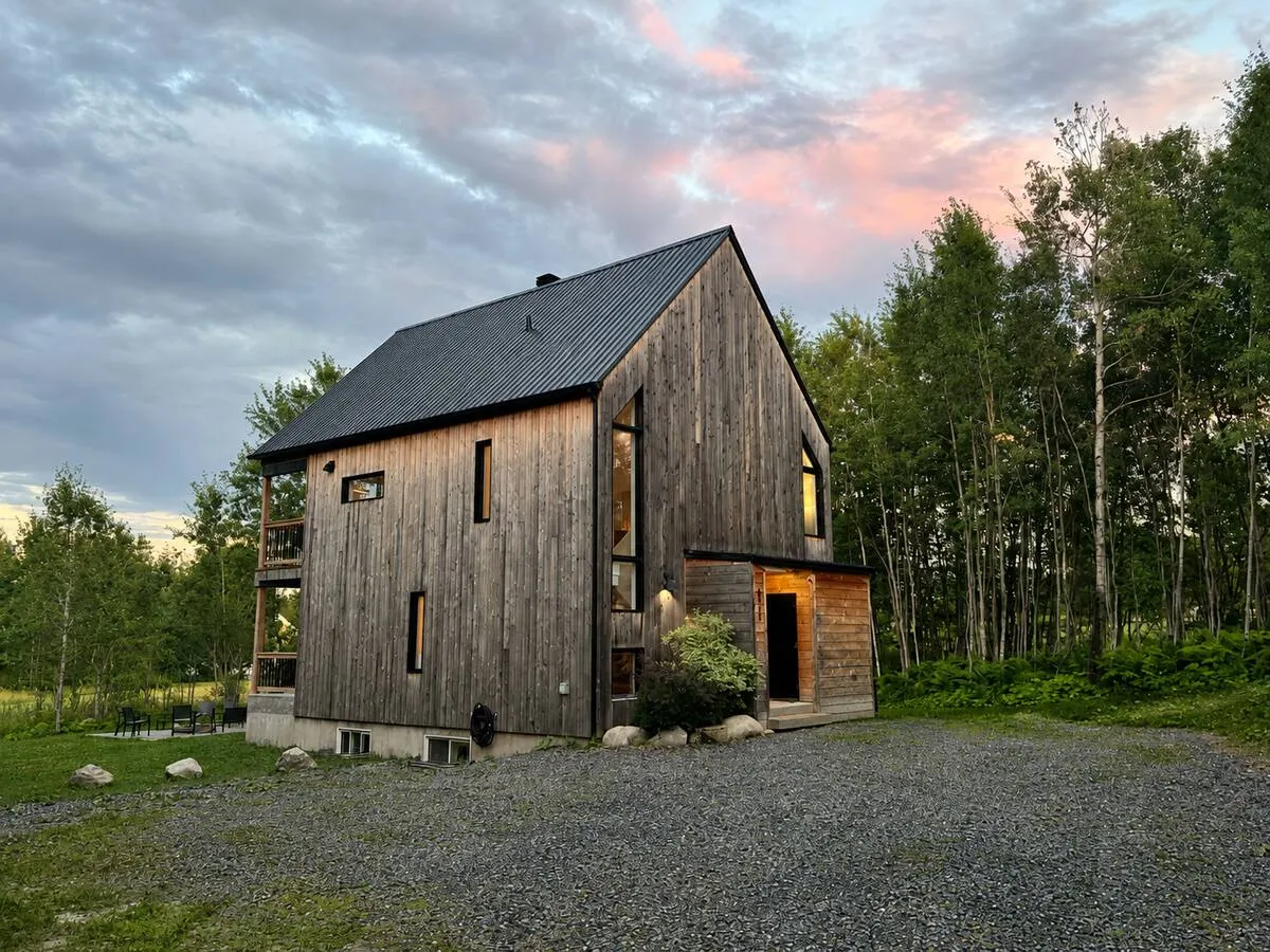 A dark-wood villa under a pink twilight sky