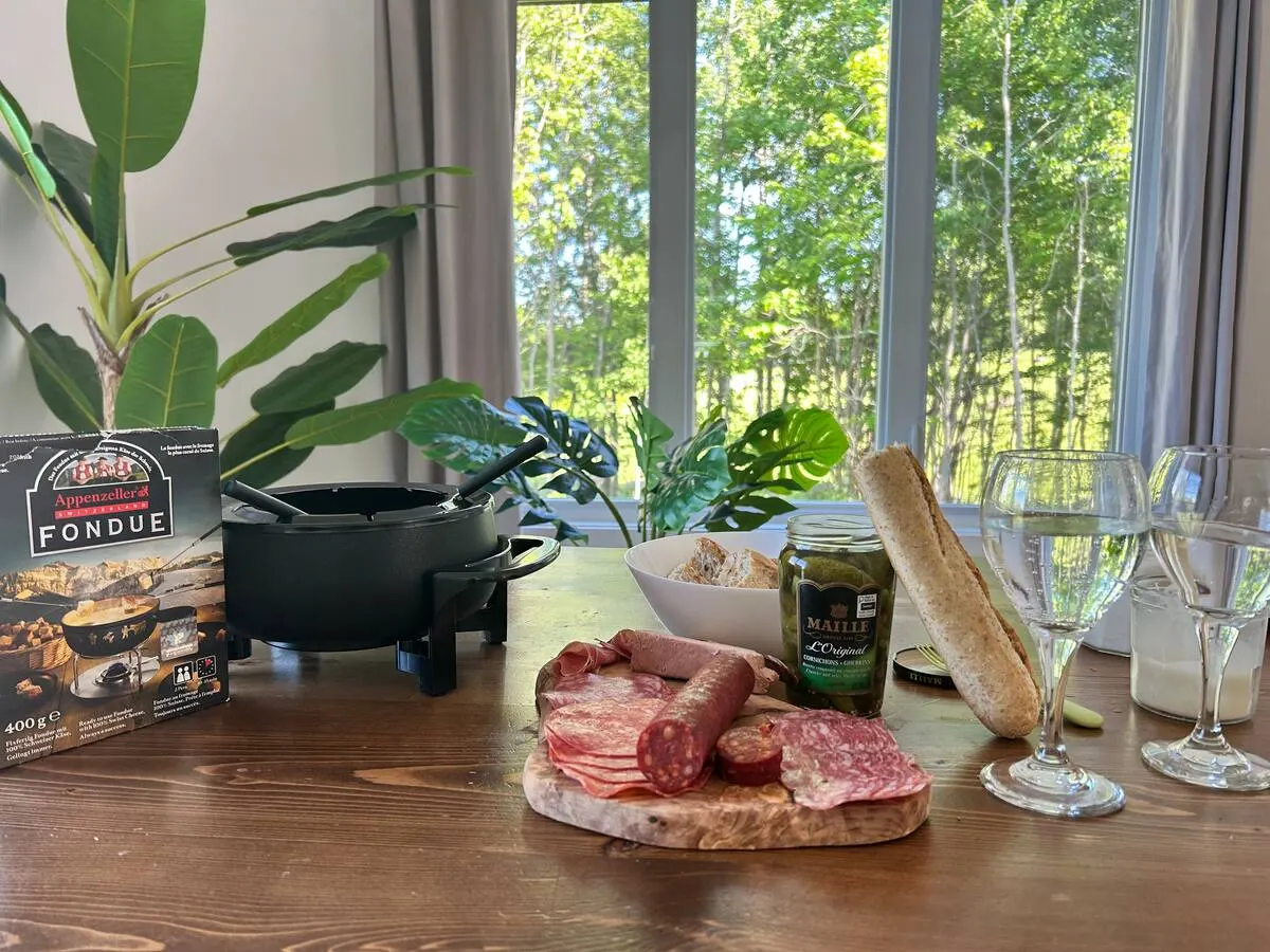 Welcome board with local charcuterie, a baguette and wine glasses beside a Villa Foresta sign and plants