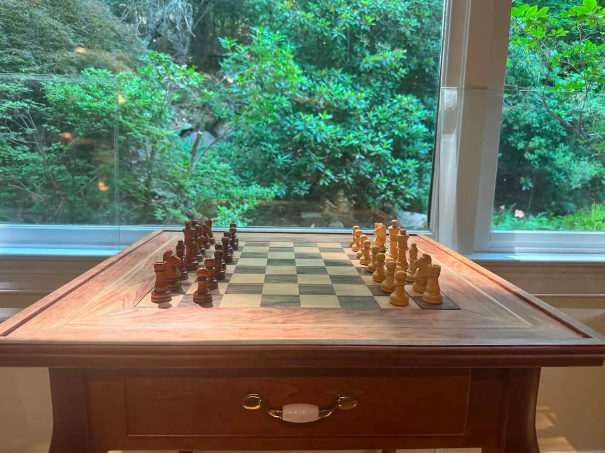 Chess table set for a game beside a window onto the forest at the Southborough home