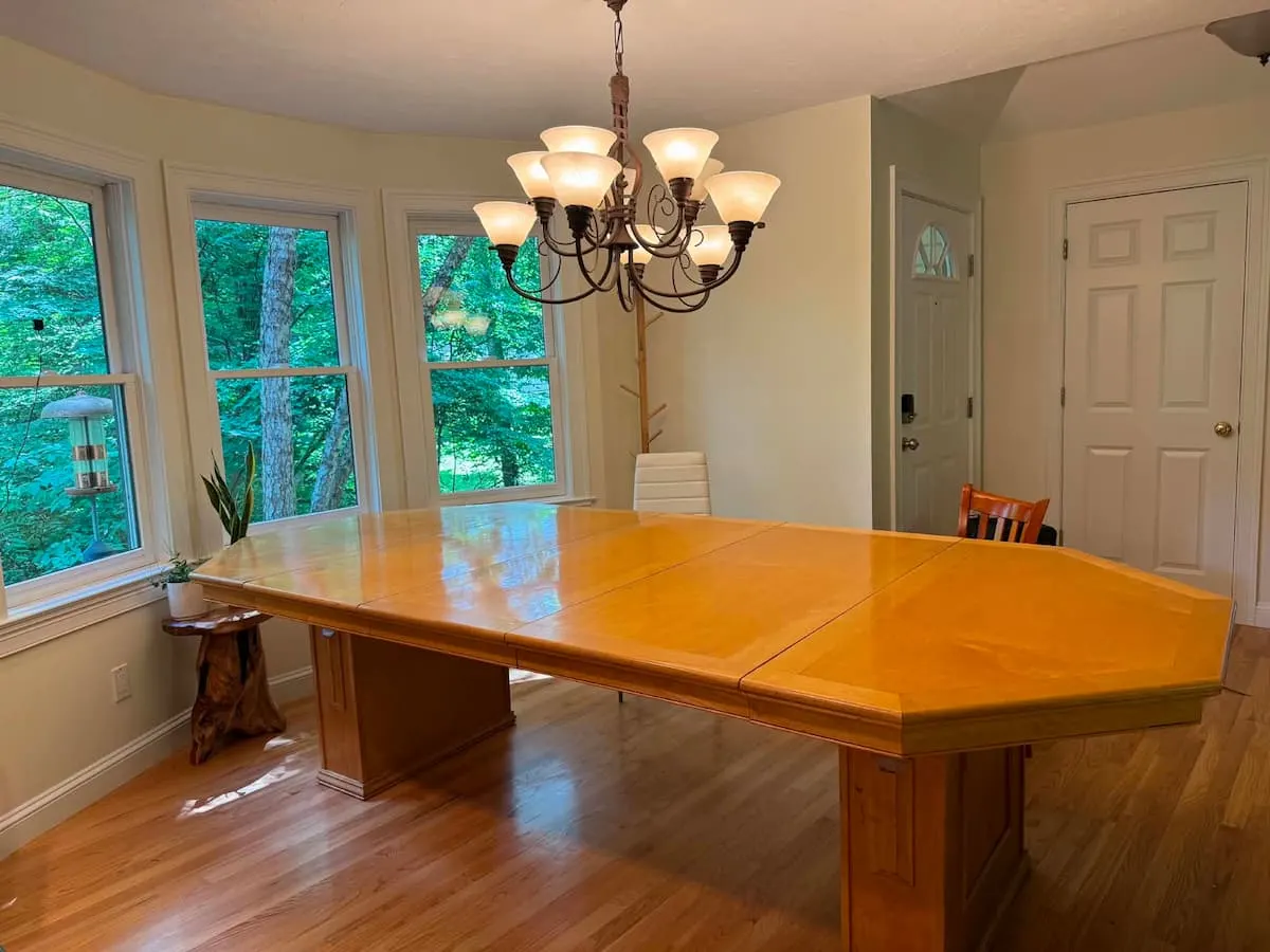 Handmade octagonal dining table under a chandelier in the Southborough home