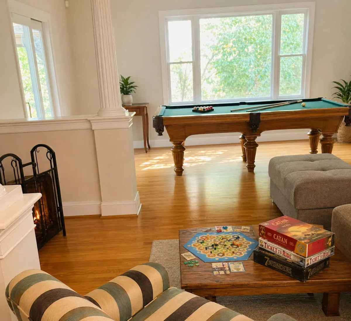 Sunlit game room in Southborough with a pool table and board games set out