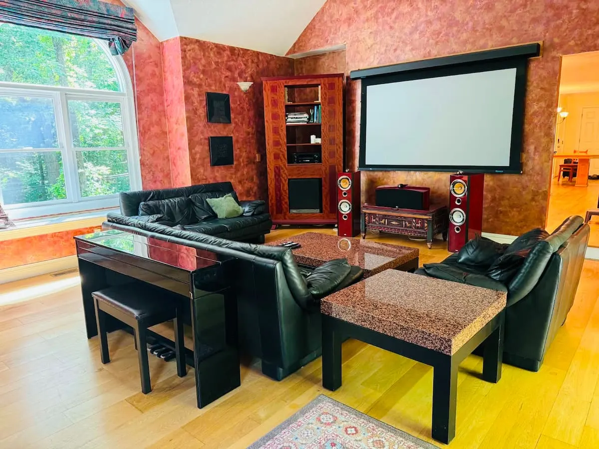 Media room at the Southborough home with a projector screen and leather seating